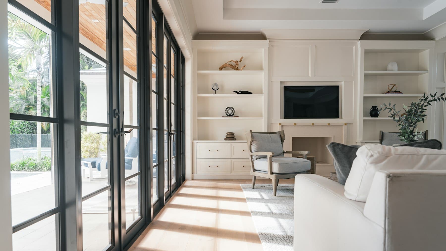 A bright staged living room with simple furniture and natural light.