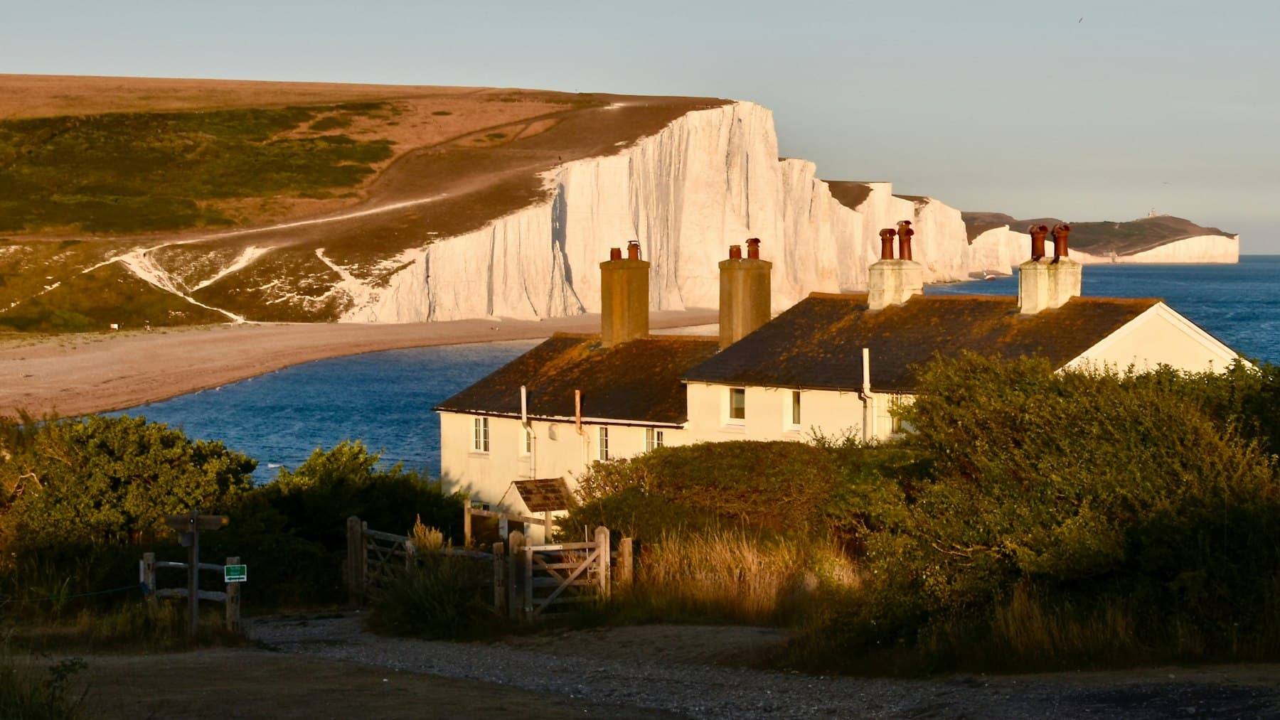 A coastal house above the water, used to represent second homes and Cornwall-style ownership from a distance.